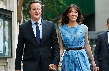 ראש ממשלת בריטניה דיוויד קמרון ואשתו סמנתה בדרך להצביע 